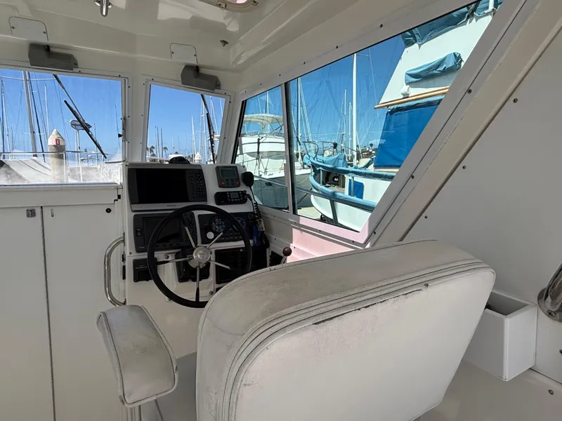 Interior view of 2004 Albin 28 TE boat cockpit with steering wheel and navigation equipment.