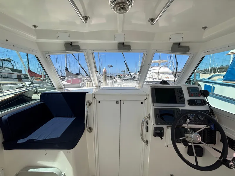 2004 Albin 28 TE boat interior with helm, navigation equipment, and marina view.