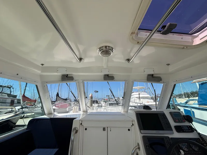 Interior view of 2004 Albin 28 TE boat with navigation equipment and marina background.