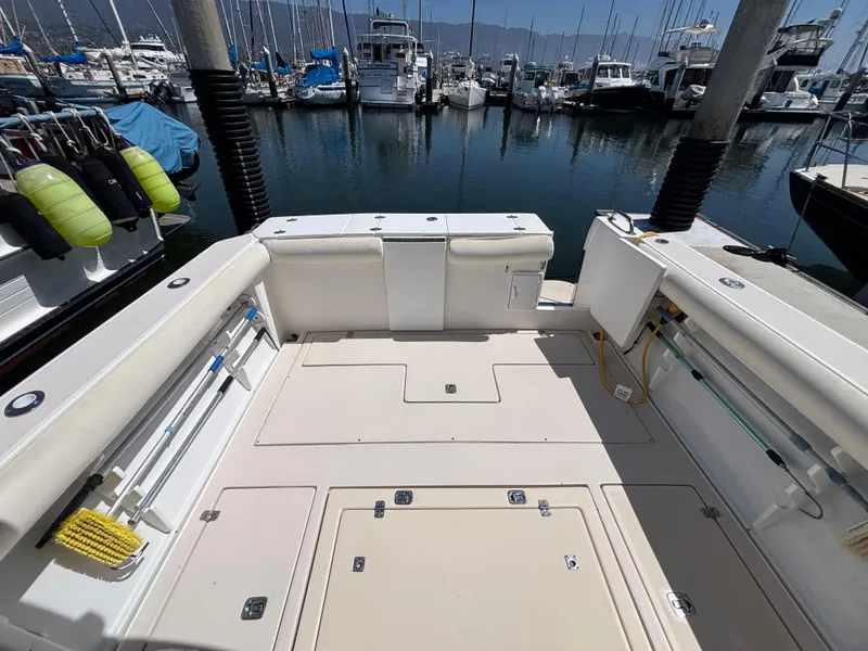 2004 Albin 28 TE boat deck in marina, surrounded by docked boats and clear water.