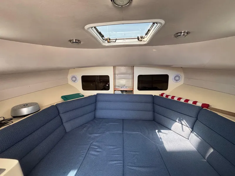 Interior of 2004 Albin 28 TE boat with blue cushioned seating and overhead hatch.