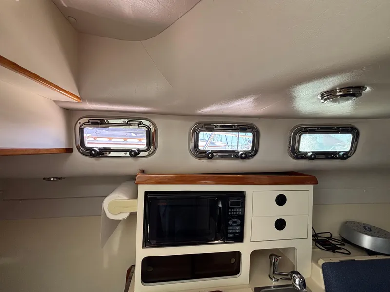 Interior of 2004 Albin 28 TE boat with microwave and porthole windows.