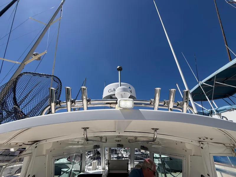 2004 Albin 28 TE boat with radar and fishing rod holders under clear blue sky.