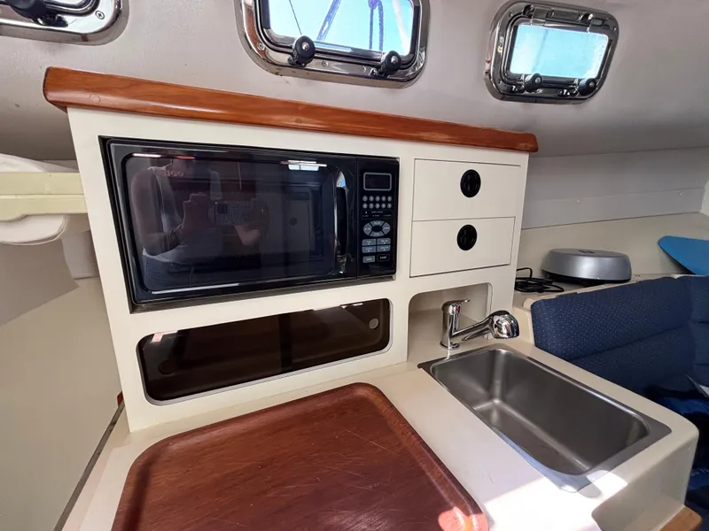 2004 Albin 28 TE boat interior with microwave, sink, and storage compartments.