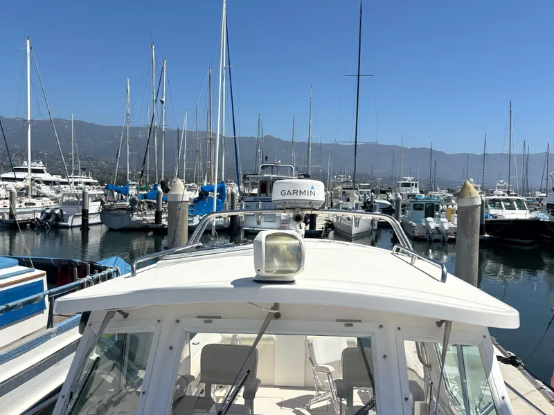 2004 Albin 28 TE boat docked in a marina with sailboats and mountains.