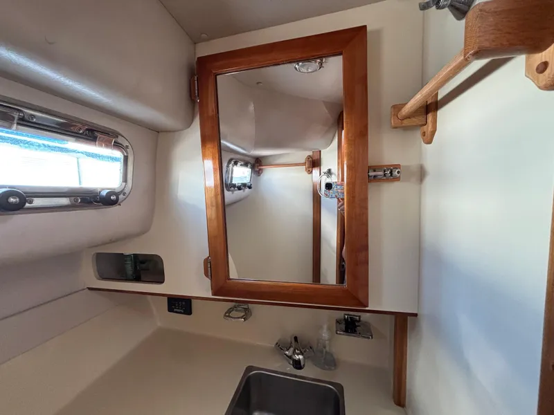 2004 Albin 28 TE boat interior with wooden-framed mirror and sink.