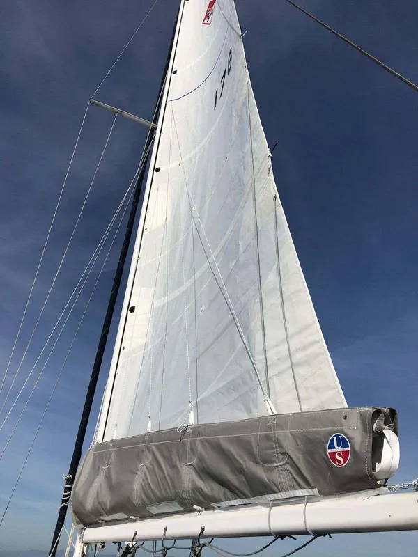 Sail of a 1986 Catalina 34 yacht against a clear blue sky.