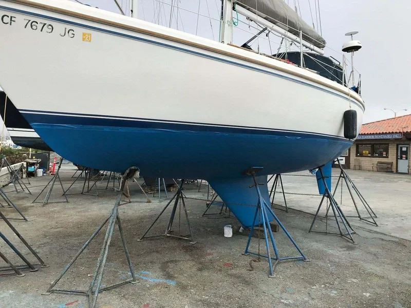 1986 Catalina 34 sailboat on stands, blue hull, marina setting.