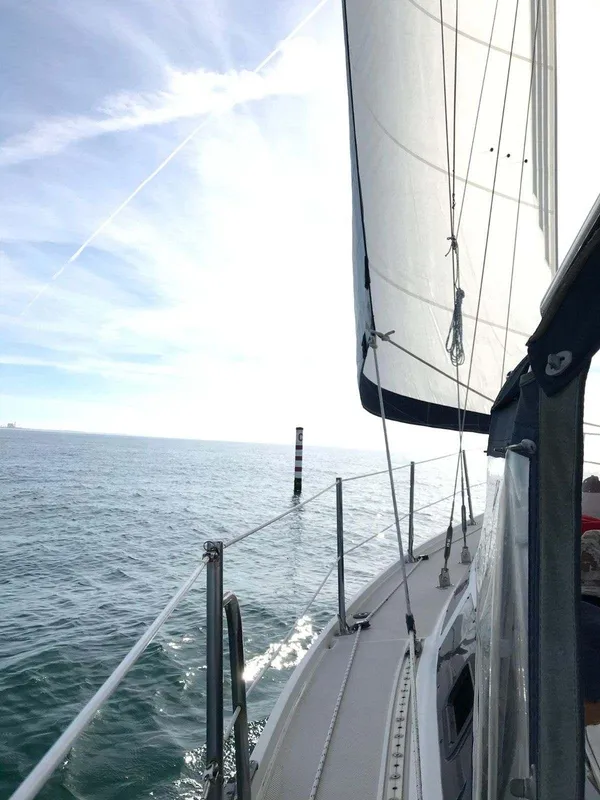 1986 Catalina 34 sailboat cruising on open sea under clear skies.
