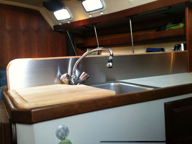 Interior of 1986 Catalina 34 sailboat kitchen with sink and cutting board.
