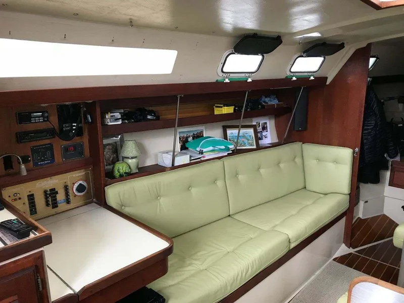 Interior of 1986 Catalina 34 sailboat with green cushioned seating and wooden accents.