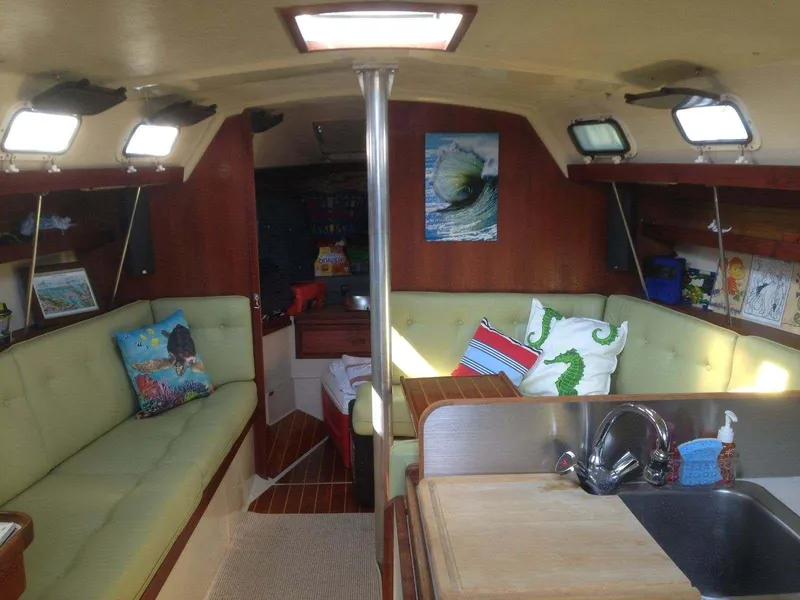 Interior of 1986 Catalina 34 sailboat with cozy seating and nautical decor.