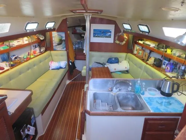Interior of a 1986 Catalina 34 sailboat with cozy seating and kitchen area.