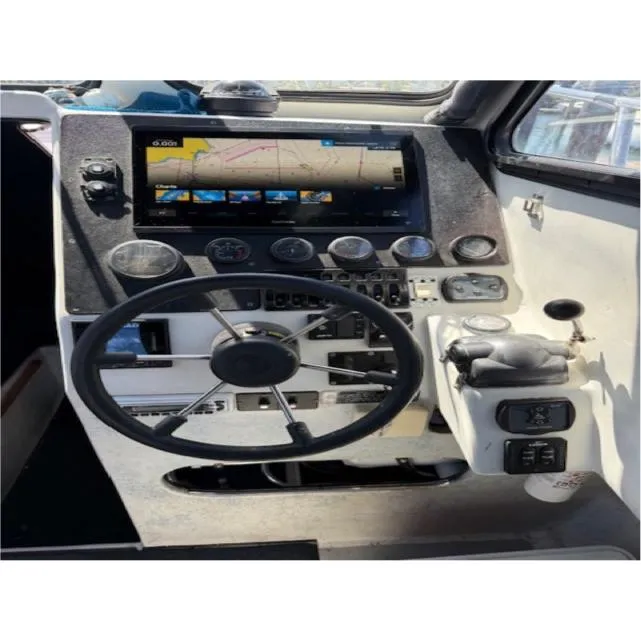 Boat cockpit of 2007 Radon Signature 26 with steering wheel and navigation display.