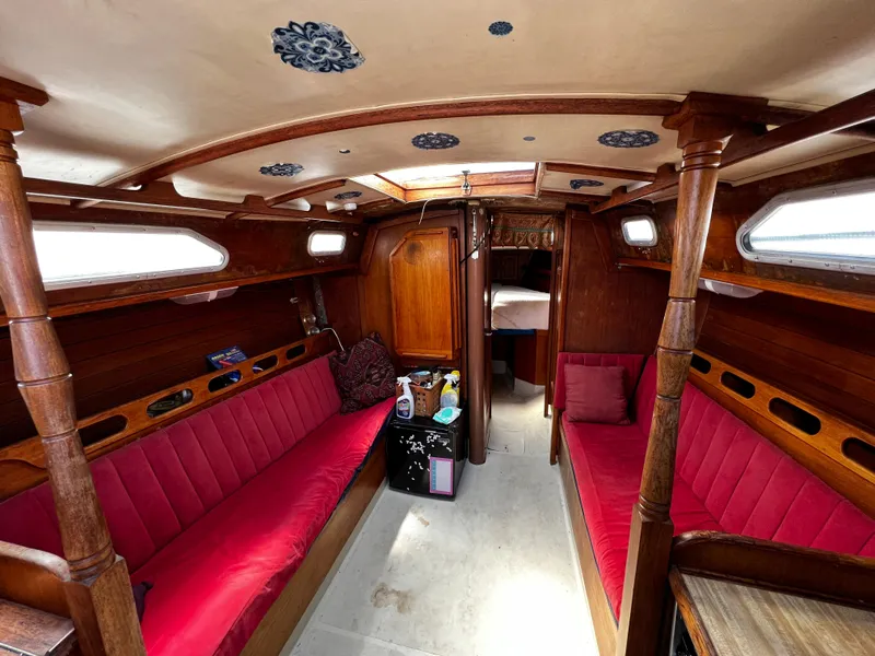 1978 Ericson 35 Sloop interior with red seating, wooden finishes, and ceiling decor.