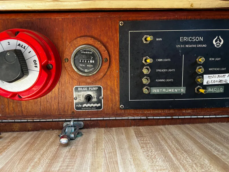 Control panel of a 1978 Ericson 35 Sloop sailboat with various switches and gauges.