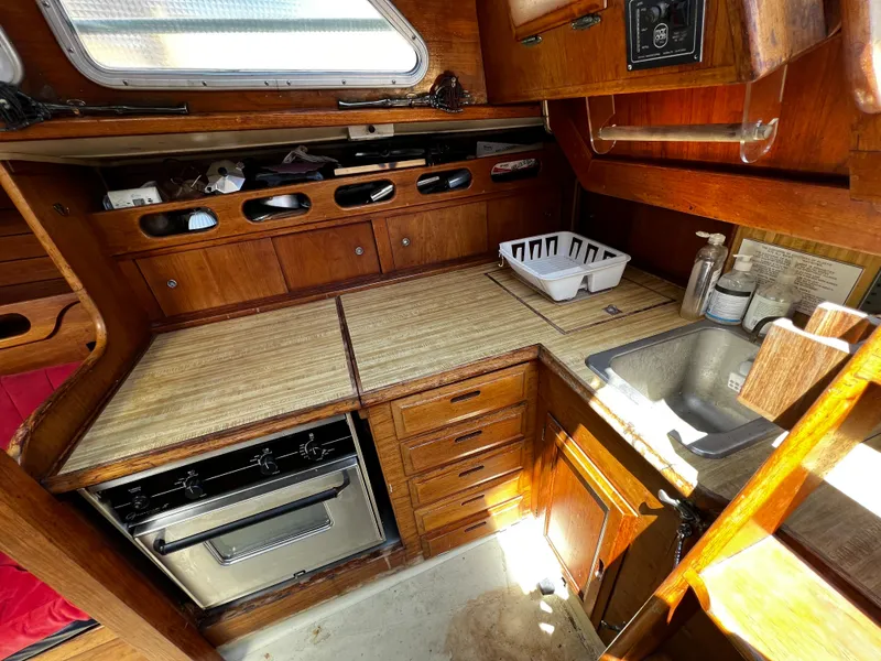 1978 Ericson 35 Sloop galley with wood cabinetry, stove, sink, and ample storage.