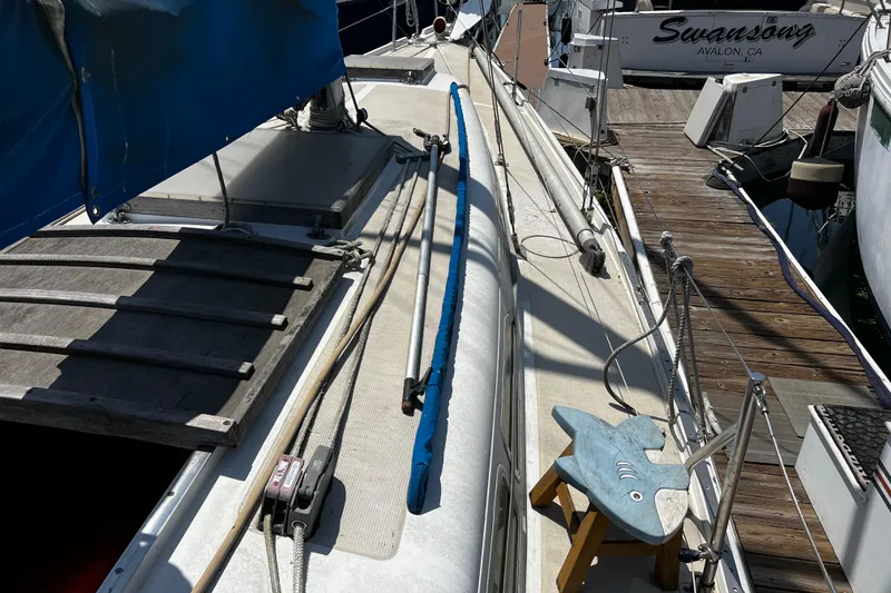 1978 Ericson 35 Sloop sailboat deck with blue sail cover and docked at marina.