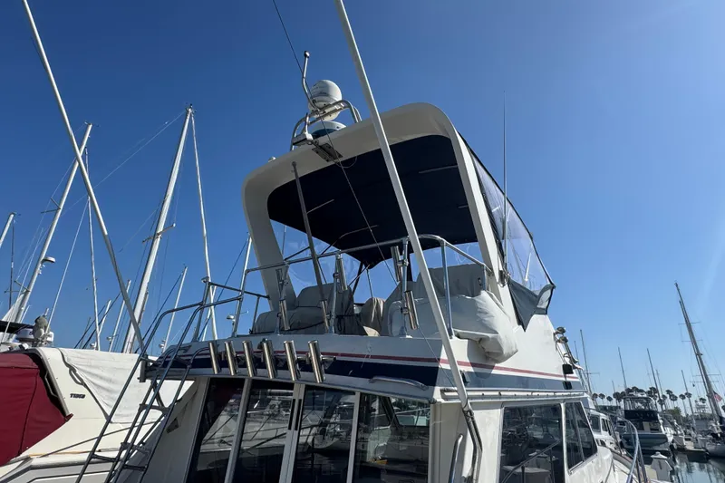 1977 Tollycraft 37 Convertible yacht docked under clear blue sky.
