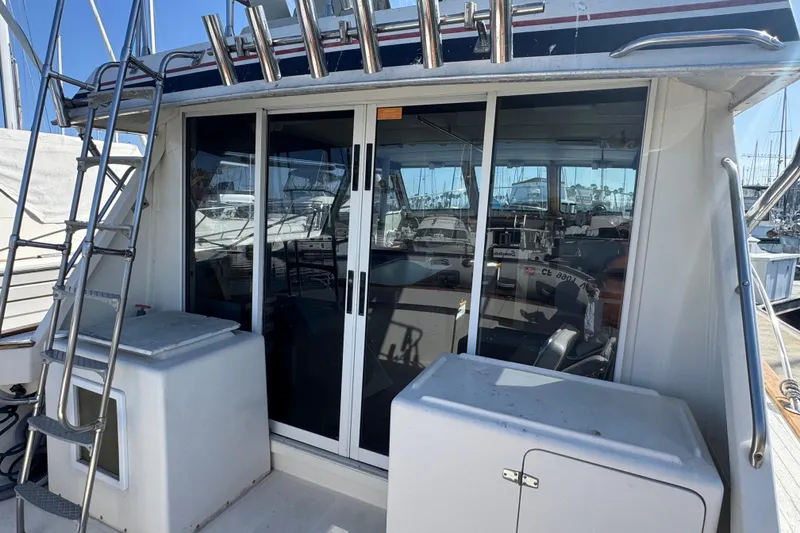 1977 Tollycraft 37 Convertible yacht with sliding glass doors and ladder on deck.