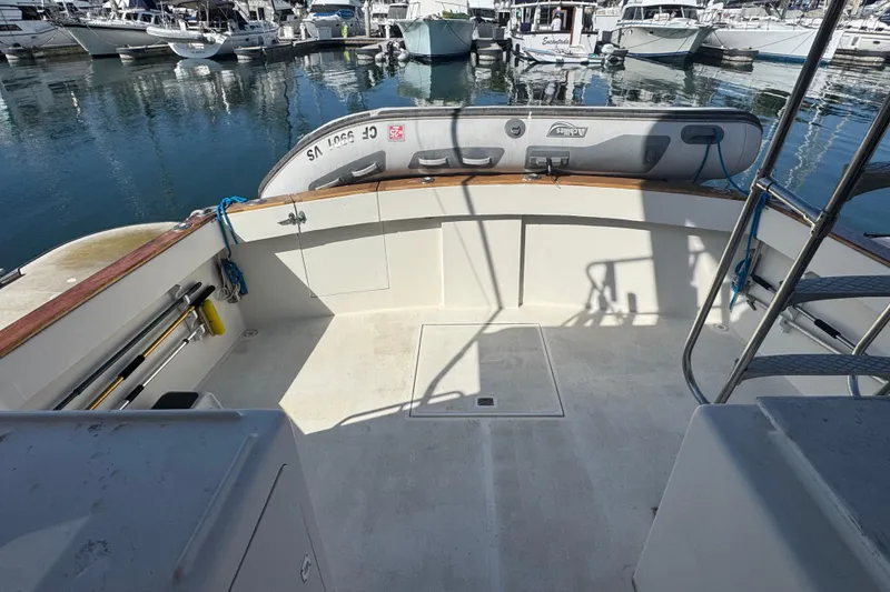 1977 Tollycraft 37 Convertible boat deck with docked inflatable dinghy.