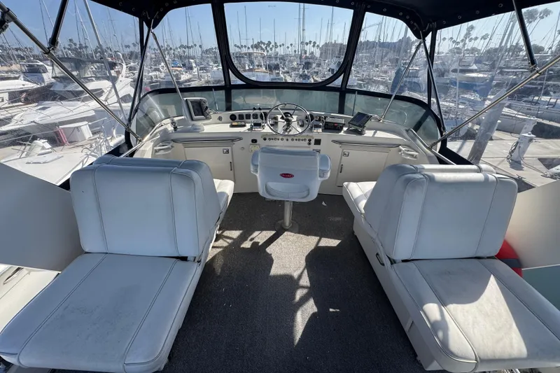 1977 Tollycraft 37 Convertible yacht cockpit with white seating and marina view.