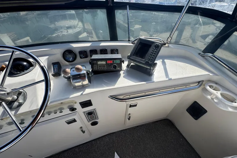 1977 Tollycraft 37 Convertible helm with steering wheel, gauges, and navigation equipment.