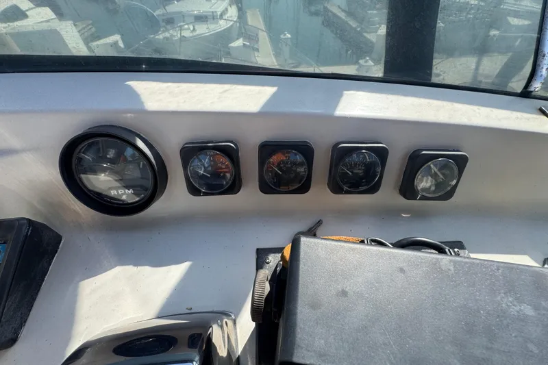 Dashboard of a 1977 Tollycraft 37 Convertible boat with various gauges and controls.