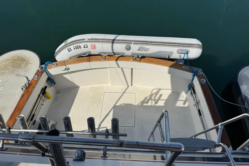 The image shows the stern of a 1977 Tollycraft 37 Convertible with a dinghy.