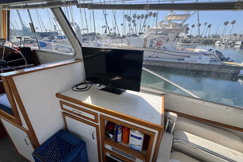 Interior of 1977 Tollycraft 37 Convertible yacht with TV and marina view.