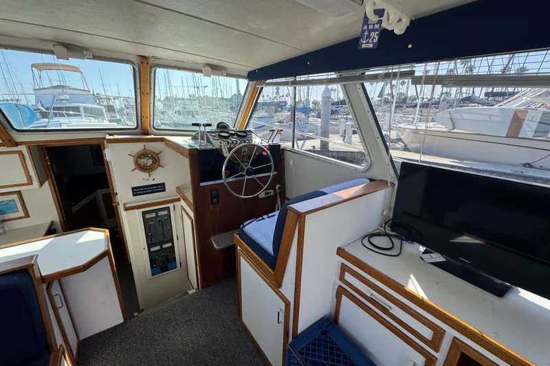 1977 Tollycraft 37 Convertible interior with helm, seating, and marina view.