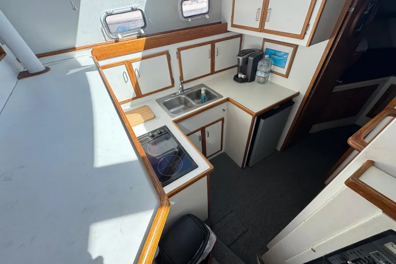1977 Tollycraft 37 Convertible yacht kitchen with stove, sink, and cabinets.