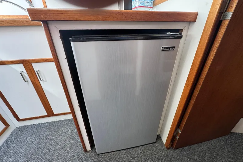 Compact Magic Chef refrigerator in a 1977 Tollycraft 37 Convertible boat interior.