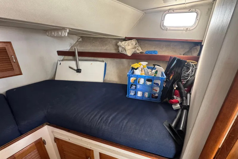 1977 Tollycraft 37 Convertible cabin interior with cleaning supplies and storage.