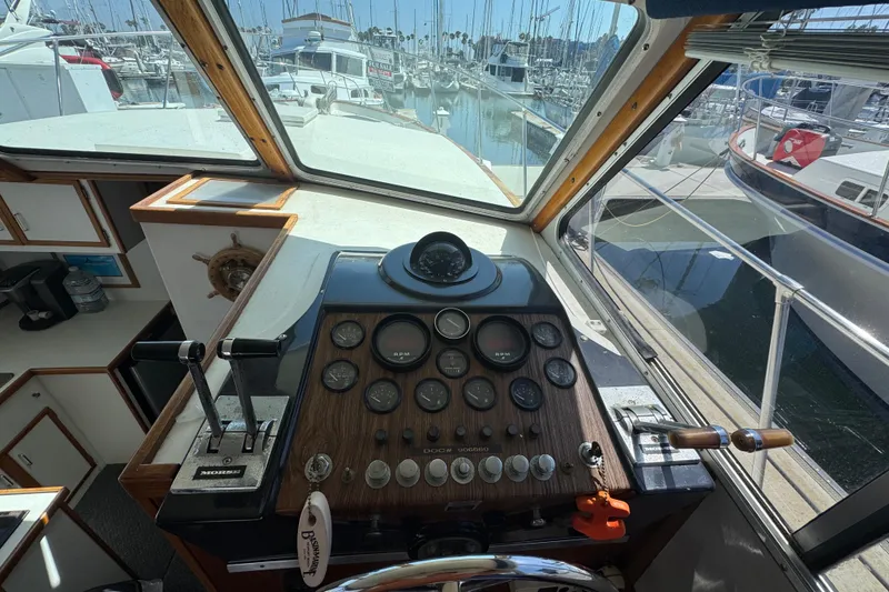 1977 Tollycraft 37 Convertible helm with gauges and controls, docked at marina.