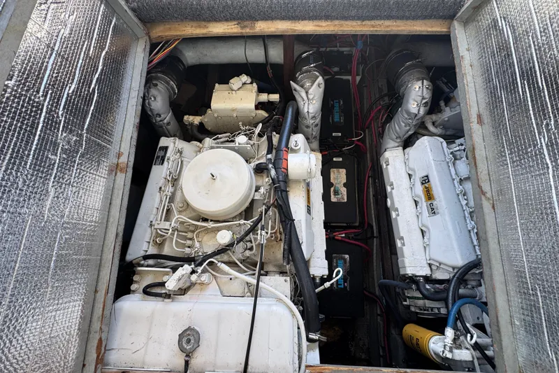 Engine compartment of a 1977 Tollycraft 37 Convertible boat, showcasing dual engines and wiring.