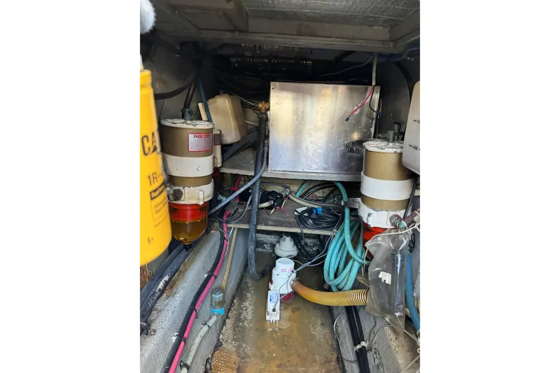 Engine room of a 1977 Tollycraft 37 Convertible with visible fuel filters and wiring.