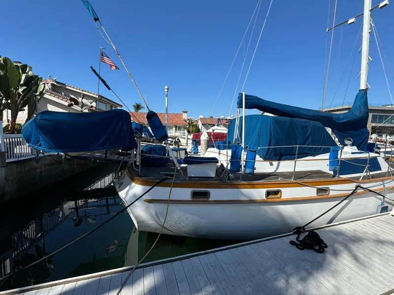 1984 Transpacific Marine Ketch docked at marina, blue covers, clear sky.