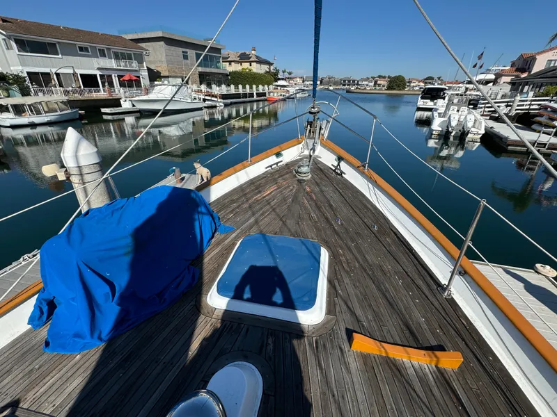 1984 Transpacific Marine Ketch docked in a serene marina, clear blue sky above.