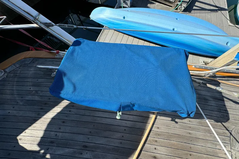 1984 Transpacific Marine Ketch deck with blue cover and wooden planks.