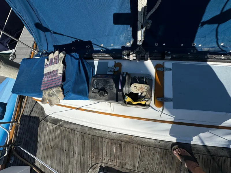 1984 Transpacific Marine Ketch deck with winch, gloves, and blue cover.