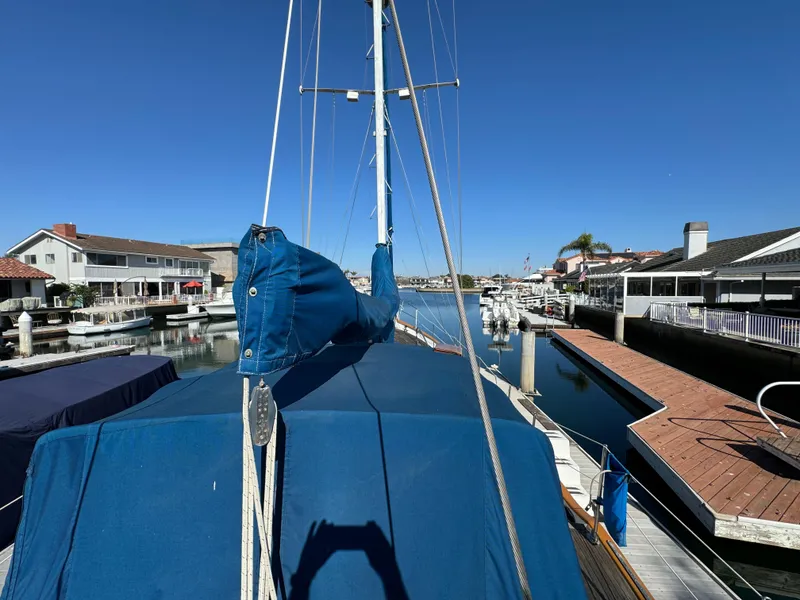 1984 Transpacific Marine Ketch docked in a sunny marina, blue sails covered.