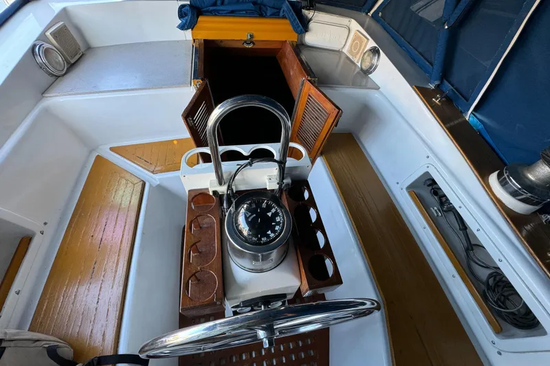 1984 Transpacific Marine Ketch cockpit with compass, wooden seating, and open cabin doors.