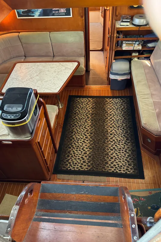 Interior of 1984 Transpacific Marine Ketch with cozy seating and leopard-print rug.