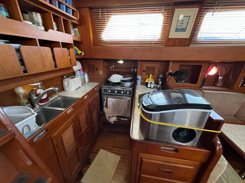 1984 Transpacific Marine Ketch interior kitchen with wooden cabinetry and modern appliances.