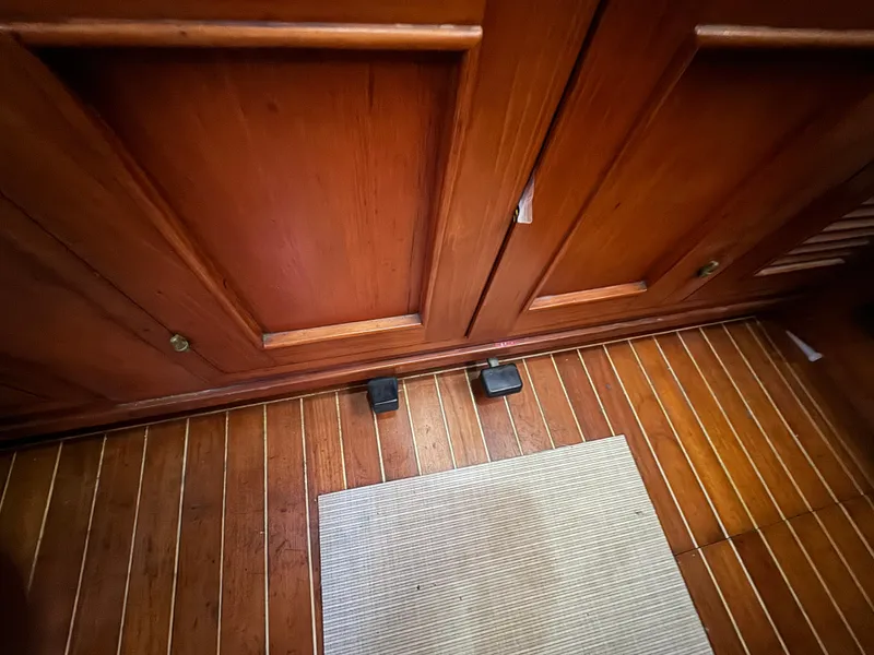 Wooden interior of a 1984 Transpacific Marine Ketch with carpet.