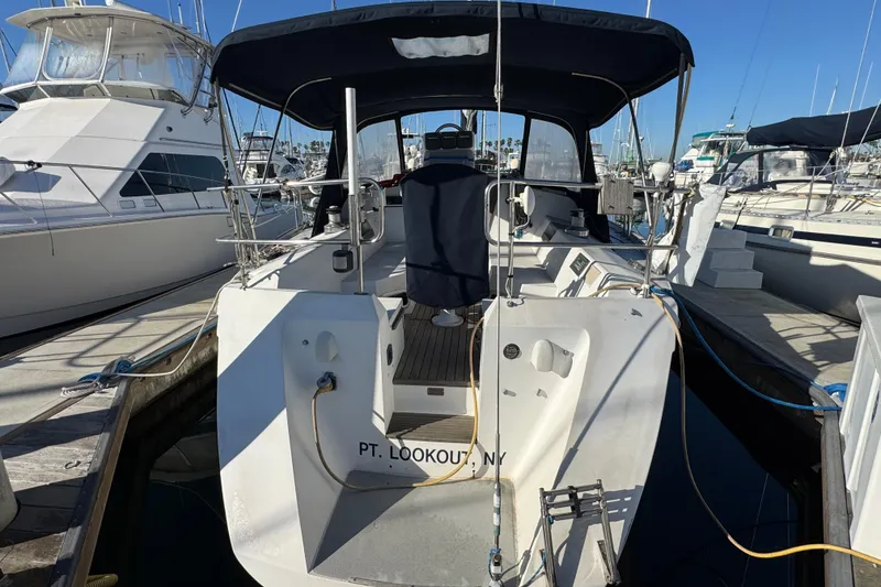 1989 Catalina 42 sailboat docked at marina, featuring covered cockpit and sleek design.