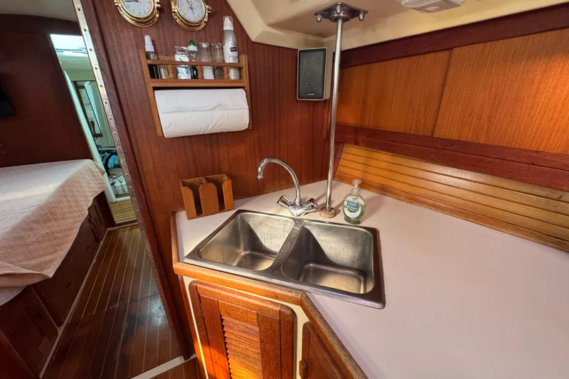 Galley of 1989 Catalina 42 sailboat with wooden cabinetry and dual sink.
