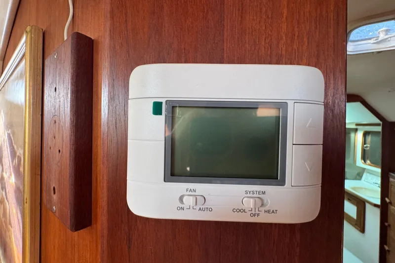 Thermostat on wooden panel inside 1989 Catalina 42 yacht cabin.
