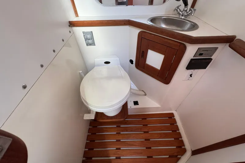 1989 Catalina 42 yacht bathroom with toilet, sink, and wooden accents.